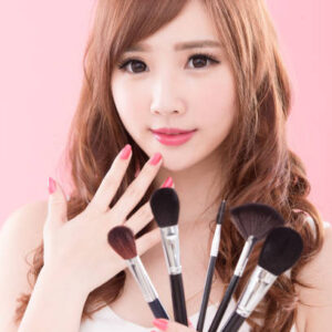beauty woman take makeup brush on the pink background